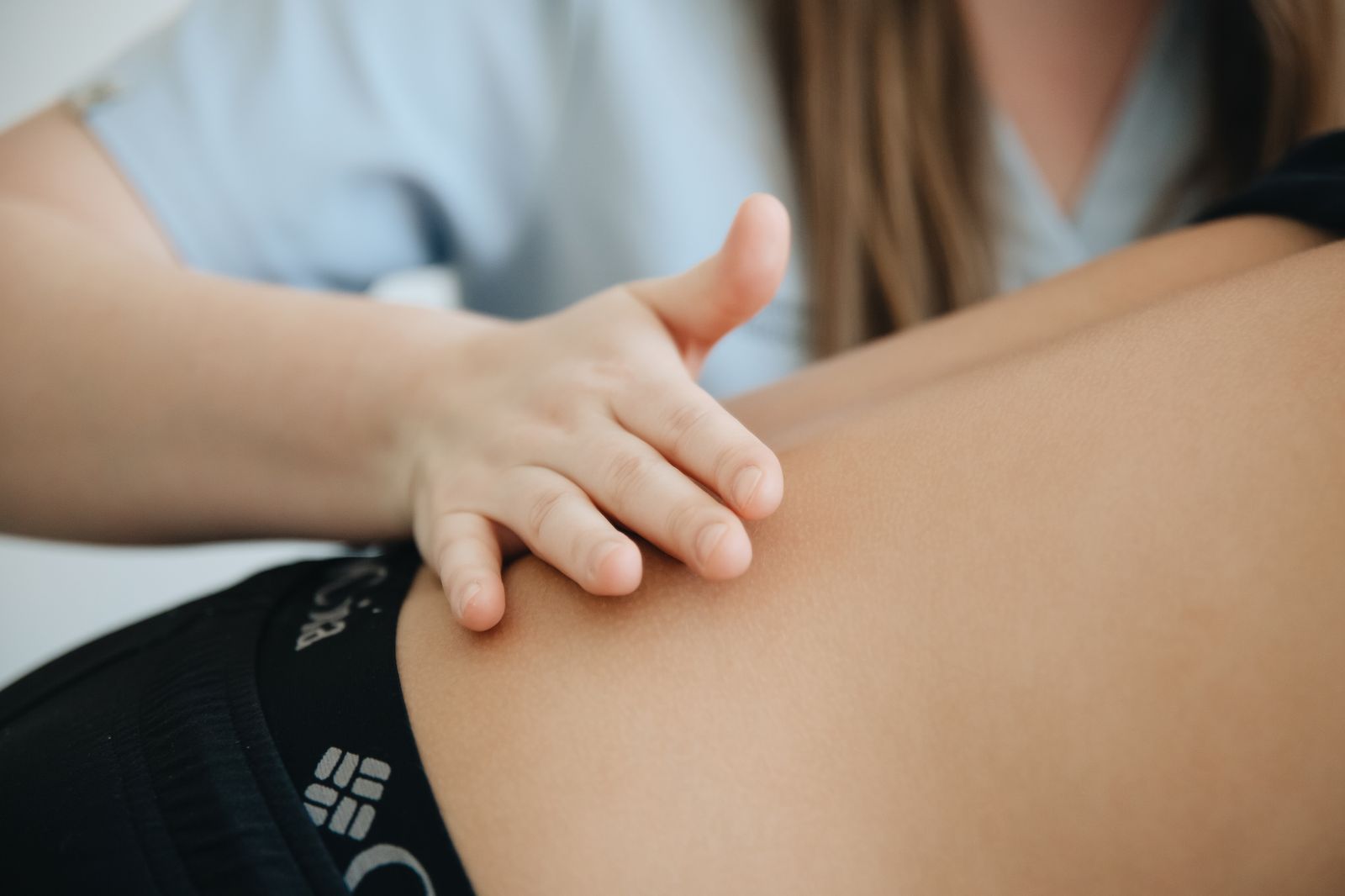 Fysiotherapeut masseert de rug van een patiënt in de praktijk