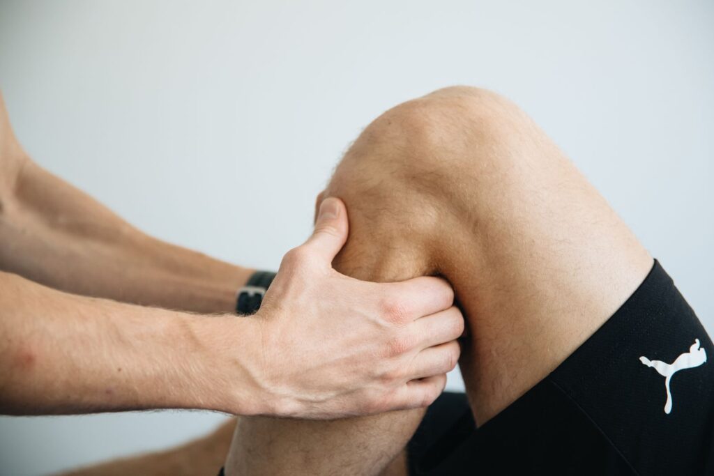 Fysiotherapeut onderzoekt de knie van een patiënt