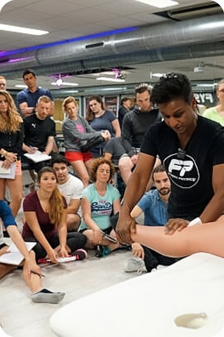 Praktijkdag Orthopedische Revalidatie: docent demonstreert een behandeling voor de groep