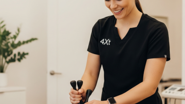 Een fysiotherapeute voert arthromyofasciale therapie uit met instrumenten op een patiënt in een kliniek.