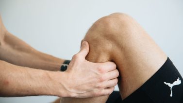 Fysiotherapeut onderzoekt de knie van een patiënt
